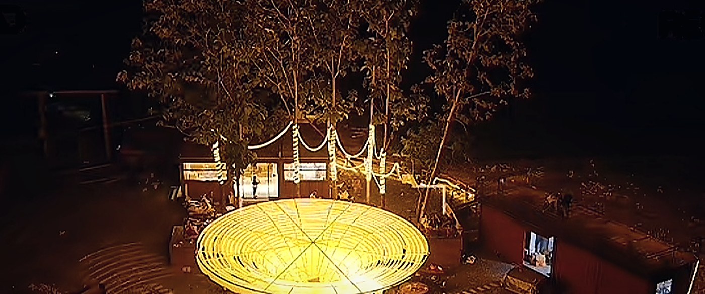 星空半岛营地夜间航拍，星穹、树木与露天营地